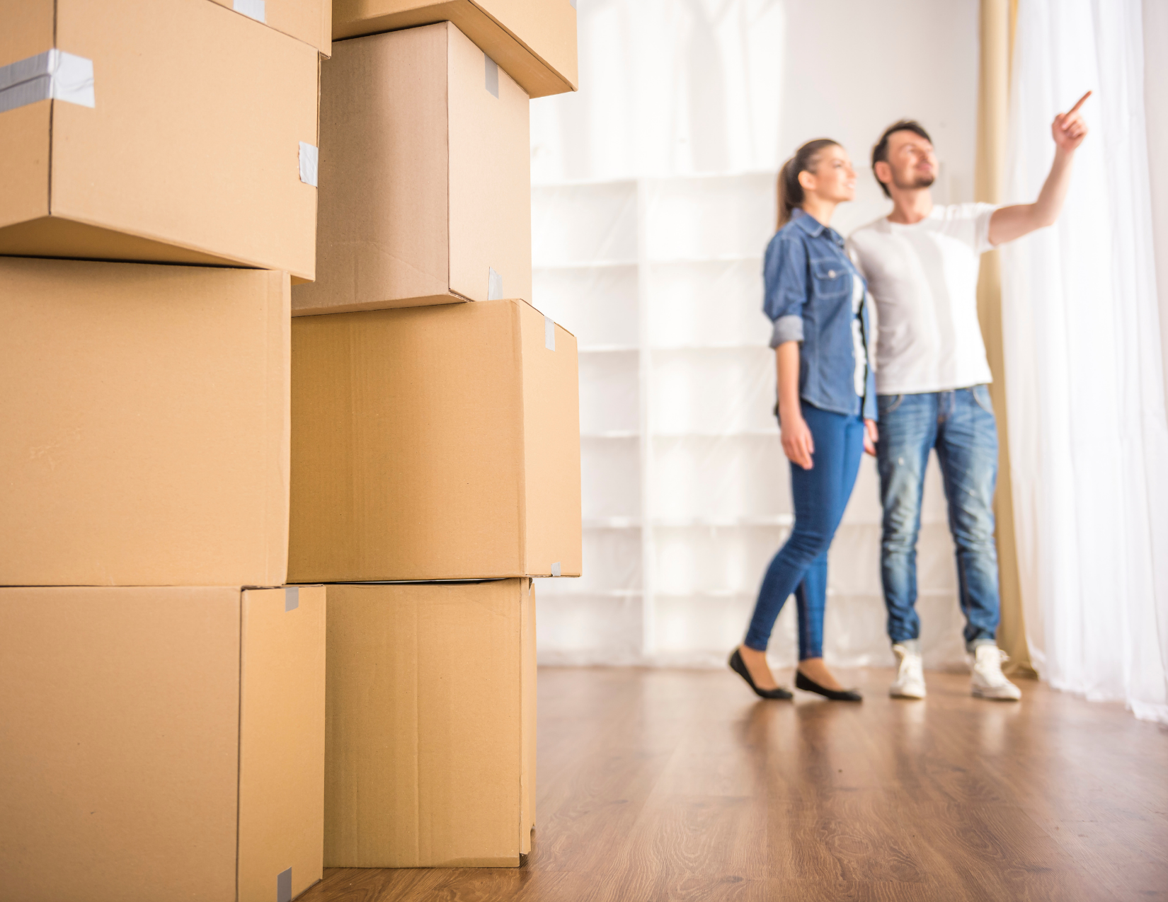 A couple with moving boxes inside a house